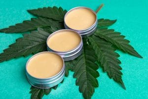 cannabis salve with hemp and cbd oil on green background